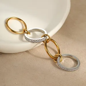 Detailansicht ineinandergreifender Gold- und Silberringe mit Zirkon-Besatz auf dem Tablett