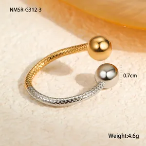 Close-up of two-tone titanium steel open ring with metal spheres and woven texture