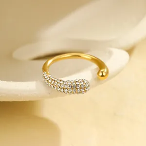 Detail eines 18K vergoldeten Rings mit glatter Kugel und funkelndem Zirkonia-Besatz