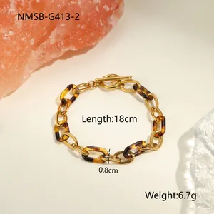 Détail du bracelet chaîne en résine de 18 cm avec fermoir à bascule doré sur fond beige