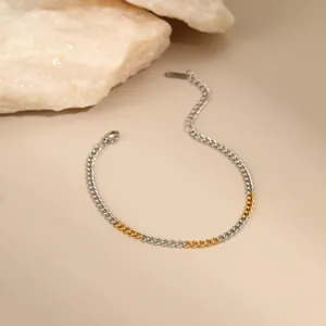 Detail of two-tone gold and silver chain necklace on minimalist beige background
