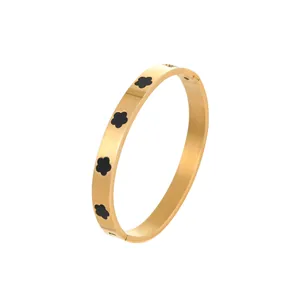Gouden roestvrijstalen armband met vijf zwarte klavermotieven op witte achtergrond