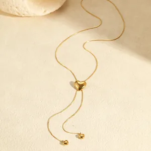 Detalle del collar en Y con corazón deslizante bañado en oro de 18K y pequeños dijes de corazón