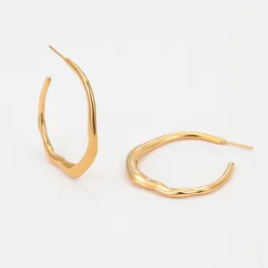 Macro shot of large 18K gold plated stainless steel hoop earrings with wavy irregular design