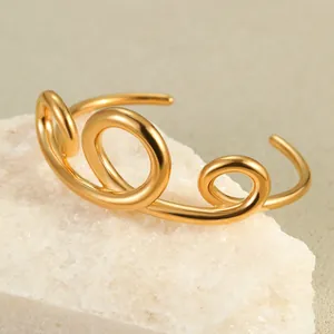 Detail of 18K gold plated stainless steel bracelet with triple spiral knot on white stone