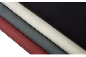 Detail shot of folded cotton fabric in burgundy, grey, off-white and black colors