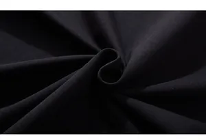 Close-up of premium black 230g cotton fabric showing fine knitted texture and soft finish