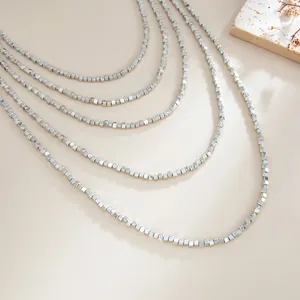 Detailed macro shot of a multi-layer minimalist silver square bead CCB necklace.