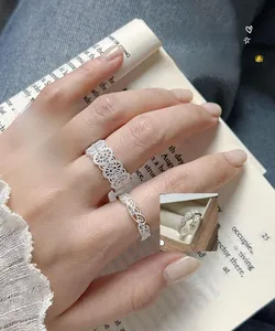 Detailed view of silver lace crown ring and vine ring with zircon stones on fingers