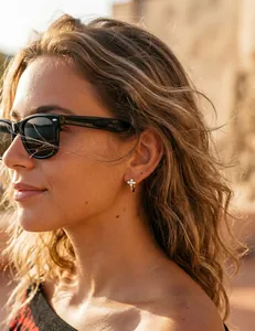 Gros plan de boucles d'oreilles trèfle plaquées or 14K avec diamants sur un mannequin