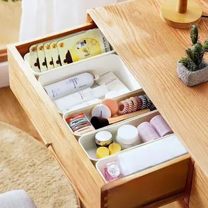 Close-up of matte white plastic drawer organizers for cosmetics and office stationery