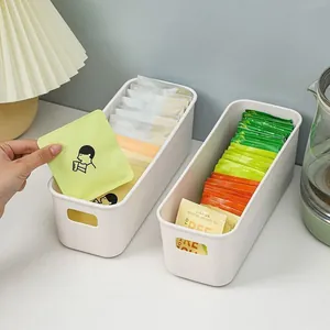 White rectangular storage box with handles containing sorted tea bags in a home setting