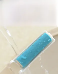 Close-up of portable lint roller being washed under water for repeated use and cleaning