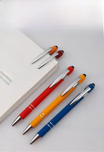 Detail of colorful metallic stylus ballpoint pens with touch tips on a white notebook