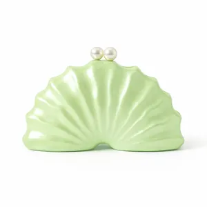 Détail d'une pochette de soirée coquillage vert clair avec fermoir en perles