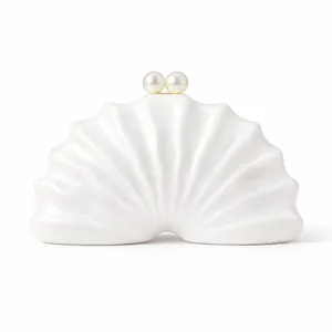 Détail du sac de soirée coquille blanche avec texture rayée et deux fermoirs perlés