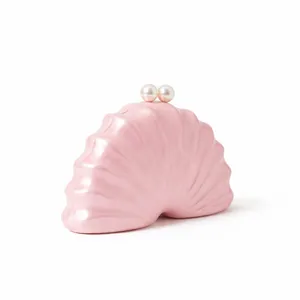 Vue détaillée du sac de soirée en forme de coquille rose nacré avec fermoir en perles