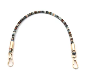 Close-up of bohemian style braided bag strap with colorful thread and gold hooks