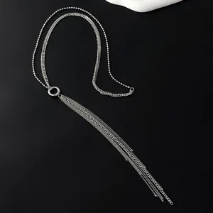 Detail of silver multi-layer tassel necklace featuring sleek chains and round ring connector