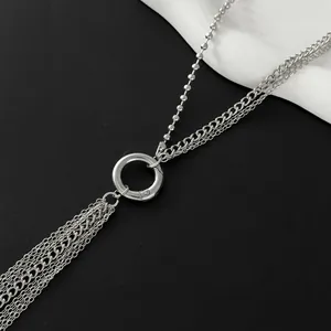 Close-up of silver layered chain necklace with industrial tassel design and metal ring