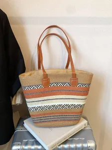 Large woven tote bag with colorful striped patterns and brown leather handles for travel