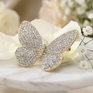 Exquisite gold butterfly brooch with shimmering white rhinestones on marble surface