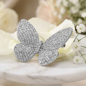 Detailed view of silver butterfly brooch with sparkling rhinestones on marble surface