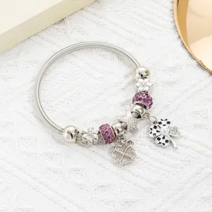 Detail of silver spring bracelet with purple crystal charms and checkered clover pendant