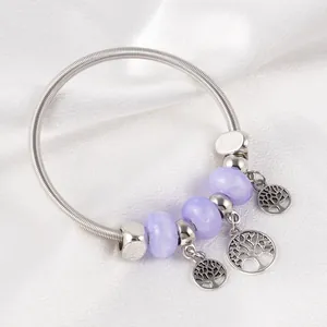 Detail of bohemian spring bracelet with purple marble beads and Tree of Life charms