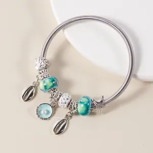Detail of ocean-themed charm bracelet with turquoise glass beads and starfish pendants