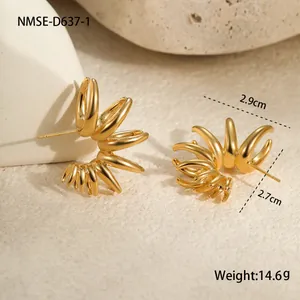 Vue macro des boucles d'oreilles géométriques dorées sur support en pierre naturelle