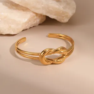 Minimalist double-layer gold plated stainless steel open bangle with central knot design