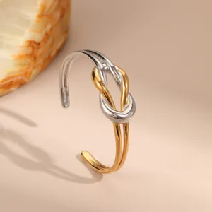 Modern two-tone knotted open cuff bracelet in polished gold and silver stainless steel