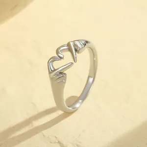 Macro view of silver adjustable ring featuring hands forming a heart shape gesture