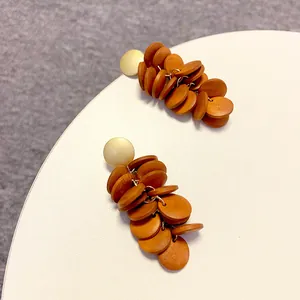 Detail view of vintage long wooden cluster drop earrings with geometric brown discs