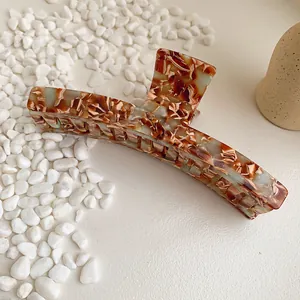 Large tortoiseshell marble acetate hair claw clip shown with natural stones