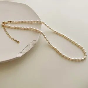 Elegant natural freshwater pearl necklace with gold lobster clasp on minimalist white tray