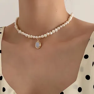 Elegant natural freshwater pearl necklace with oval moonstone pendant on a woman model
