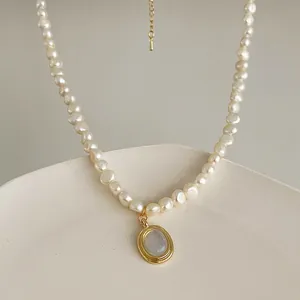 Baroque pearl necklace with oval moonstone gold pendant on white display stand