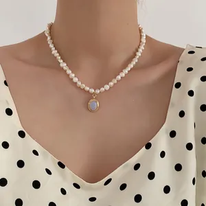 Detailed view of freshwater pearl necklace with an oval blue moonstone pendant on a model