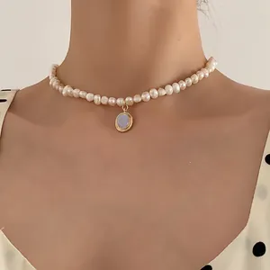 Elegant natural freshwater pearl necklace with a vintage moonstone gold pendant on a model