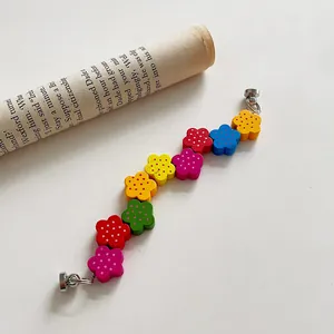 Close-up of colorful wooden flower beads and silver metal clasps for mobile phone straps