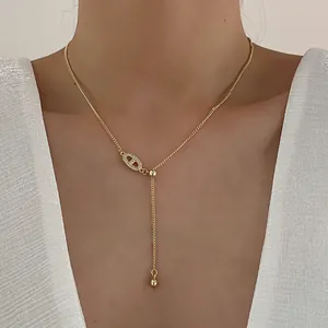 Elegante gouden Y-vormige ketting met zirkoon varkensneus hanger bij een vrouwelijk model