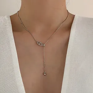 Elegante zilveren varkensneus ketting met zirkonia, gedragen door een model op een witte top