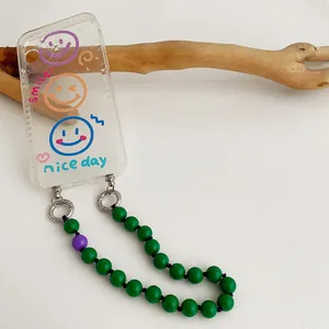 Transparent smile phone case with green beaded lanyard and purple accents on white background