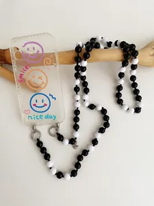 Λεπτομέρεια θήκης τηλεφώνου με πολύχρωμα smileys και ασπρόμαυρο λουράκι με χάντρες
