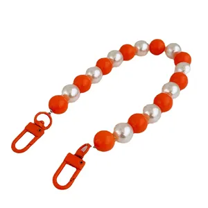 Handmade orange and pearl beaded phone chain with large lobster clasps on white background