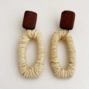 Dettaglio di orecchini in rattan intrecciato a mano con perno in legno naturale