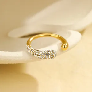 Detail eines vergoldeten offenen Rings mit Mikro-Zirkonia und minimalistischem Kugeldesign