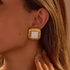 Goldene quadratische Edelstahl-Ohrringe mit weißem Achat-Imitat am Modell